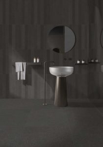 Nell’immagine elegante ambiente bagno realizzato con Lavica, la collezione di Ceramiche Keope che cattura l’essenza della pietra vulcanica siciliana. La finitura impiegata è Anthracite, a parete nel formato brick 7,5x60 e a pavimento nel formato 80x80.